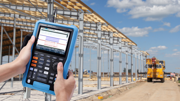 handheld oscilloscope, portable oscilloscope, Siglent handheld oscilloscope at construction site held by two hands